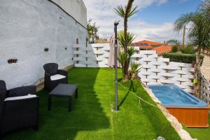 a backyard with a swimming pool and a lawn with chairs and an umbrella at Moradia Dos Castelos Azul in Ourém