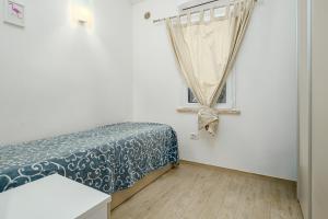 a bedroom with a bed and a window at Confortevole villetta caposchiera in San Teodoro