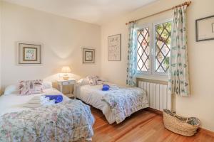 two beds in a room with a window at Villa Almeda in Port d'Andratx