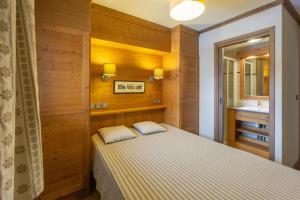 a bedroom with a bed in a room with wooden walls at Appartement B56 - Eco Le Ruitor in Sainte-Foy-Tarentaise +14 photos