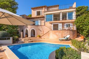 a villa with a swimming pool in front of a house at Villa Almeda in Port d'Andratx