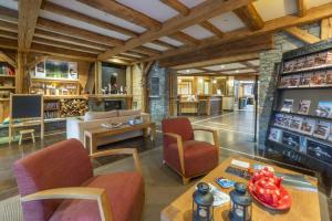 a living room with a table and chairs and a room at Appartement B56 - Eco Le Ruitor in Sainte-Foy-Tarentaise