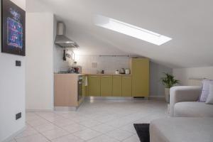 a kitchen with a yellow cabinet in a living room at Mansarda Massimo - Verbania Intra in Verbania