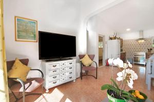 a living room with a television on a white dresser at Casa Arcadia T3 in São Bartolomeu de Messines