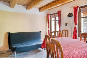 a dining room with a table and a blue couch at Carlina Tano di Grich in Cesani +12 photos