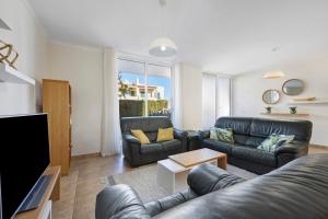 a living room with two couches and a tv at Lagos Beach Pool Villa in Lagos