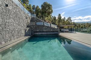 a swimming pool next to a stone wall at Buena - Vista in La Guancha