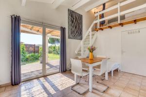 a dining room with a table and chairs and a staircase at Mas des Cypres - Mazet 5 in Saintes-Maries-de-la-Mer