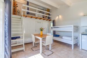 a room with a table and bunk beds at Mas des Cypres - Mazet 5 in Saintes-Maries-de-la-Mer