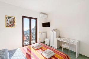 a bedroom with a bed and a desk and a window at Coast 2 Coast in Agerola