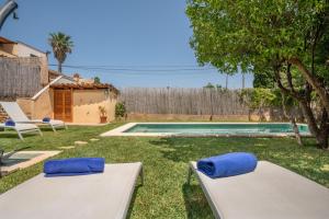 a backyard with two beds and a swimming pool at Villa Ca Na Campins in Campanet