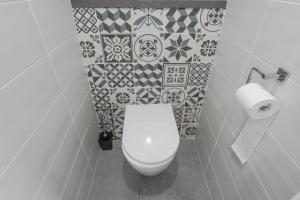 a bathroom with a toilet and tiles on the wall at Appartement dans maison atypique in Montrond-les-Bains +13 photos