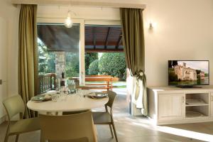a dining room with a table and a television at Al segnavento Tramontana in Toscolano Maderno