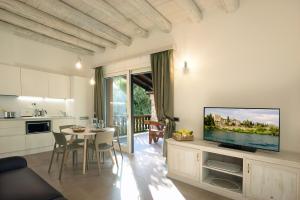 a kitchen and a living room with a tv on a wall at Al segnavento Tramontana in Toscolano Maderno