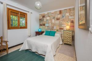 a bedroom with a bed and a brick wall at Casa de Gertrudis in El Palmar