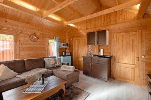 a living room with a couch and a table in a cabin at Haus Seebrise - Marina Mücheln in Mücheln