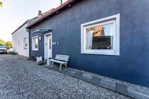 a blue building with a bench in front of a window at Insel Koje 1 in Fehmarn