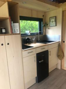 a kitchen with a sink and a black refrigerator at La tiny house de la Blandinière in Vertou