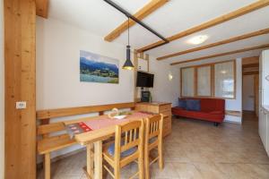 a dining room with a table and a red chair at Mühlanderhof Apt Klopairspitze in Resia