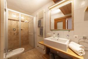 a white bathroom with a sink and a shower at Mühlanderhof Apt Klopairspitze in Resia +24 photos