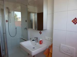 a white bathroom with a sink and a shower at Ferienwohnung Diepold in Wasserburg +32 photos