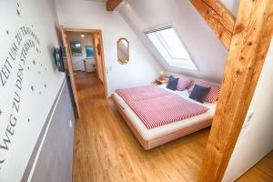 a small attic bedroom with a bed and a window at Trenklehof in Simonswald