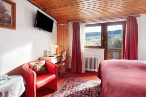 a bedroom with a bed and a chair and a window at Hotel Bären - drei Sterne in Bernau im Schwarzwald