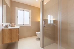 a bathroom with a toilet and a glass shower at Blue Coast Apartment in Canet de Mar +15 photos