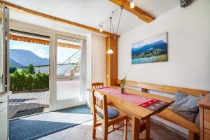 a dining room with a table and a balcony at Mühlanderhof Apt Klopairspitze in Resia