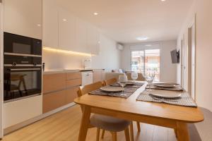 a kitchen and dining room with a wooden table and chairs at Blue Coast Apartment in Canet de Mar