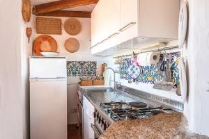 a kitchen with a stove and a refrigerator at Casa Mucchi Bianchi PC33 in Arzachena +18 photos