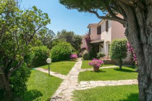 a garden with pink flowers and a house at Casa Mucchi Bianchi PC33 in Arzachena