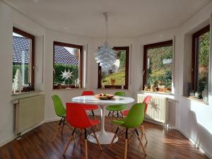 a dining room with a white table and green chairs at Ferienwohnung Panoramablick in Bad Wildbad