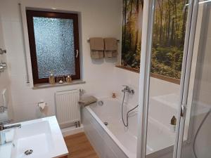 a bathroom with a shower and a bath tub at Ferienwohnung Panoramablick in Bad Wildbad +36 photos
