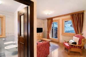 a bathroom with a sink and a toilet and a chair at I Mini Appartamenti in Livigno