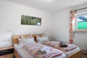 two twin beds in a room with a window at Haus Intlekofer in Lenzkirch