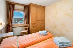 a small bedroom with an orange bed and a window at I Mini Appartamenti in Livigno