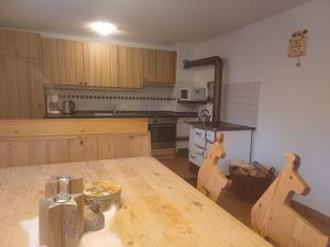 a kitchen with a wooden table and a kitchen with a counter at Ferienhaus Lemberger in Jochberg