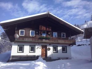 a house with a balcony in the snow at Ferienhaus Lemberger in Jochberg