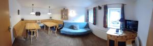 a living room with a blue couch and a table at Ferienhaus Lemberger in Jochberg