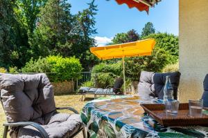 a table with a yellow umbrella on a patio at Schwabenseenestle in Uhldingen-Mühlhofen