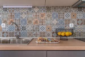 a kitchen counter with a sink and a tray of food at Martha's House in Spetses +19 photos