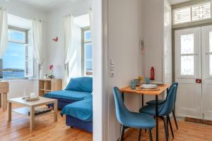 a living room with a table and a blue couch at Martha's House in Spetses