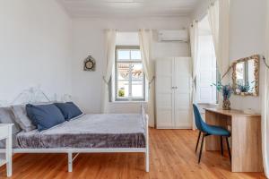 a bedroom with a bed and a desk and a chair at Martha's House in Spetses
