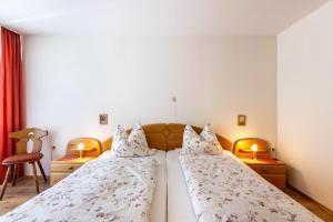 two beds in a hotel room with two lamps at Lorenz in Triberg