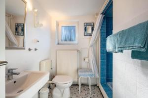 a white bathroom with a sink and a toilet at Ferienhaus Bondelum in Bondelum +59 photos