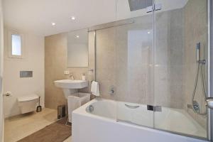 a bathroom with a tub and a sink and a toilet at Maina 1919 in Pollença +7 photos