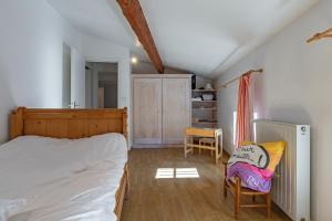 a bedroom with a bed and two chairs in it at Typical House Completely Renovated in Saint-Alban-dʼAy
