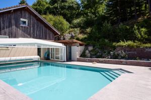 a large swimming pool in front of a house at Chalet les moraines 8 in Le Tholy