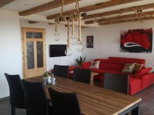 a living room with a red couch and a table at Fischerhof in Höchenschwand
